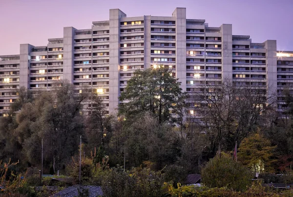 Familiengärten vor der Telli-Siedlung in Aarau bei Sonnenuntergang – ein Kontrast zwischen urbaner Architektur und privatem Rückzug.